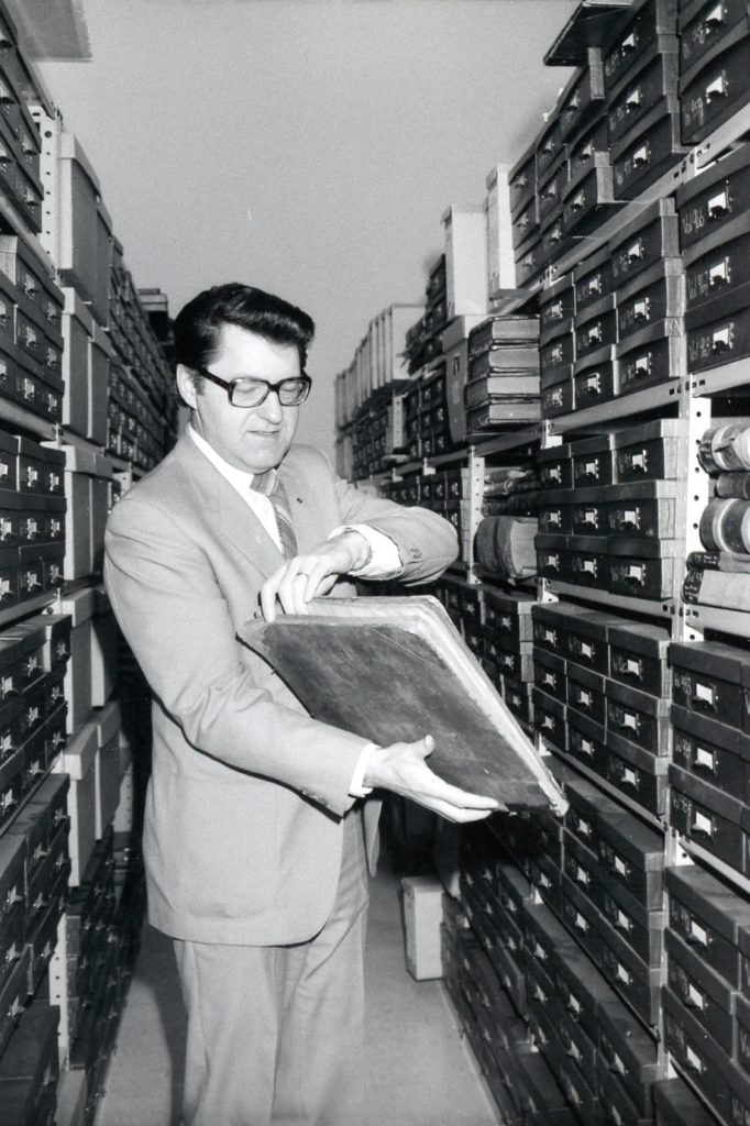 Lawrence Klippenstein looking at an old book in the vault of the Mennonite Heritage Archives in 1984